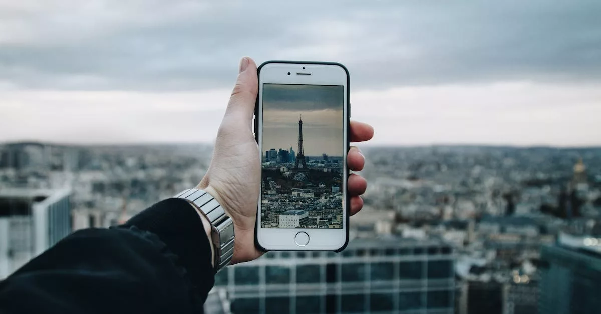A person uses a smartphone to capture the Eiffel Tower amidst a panoramic cityscape.