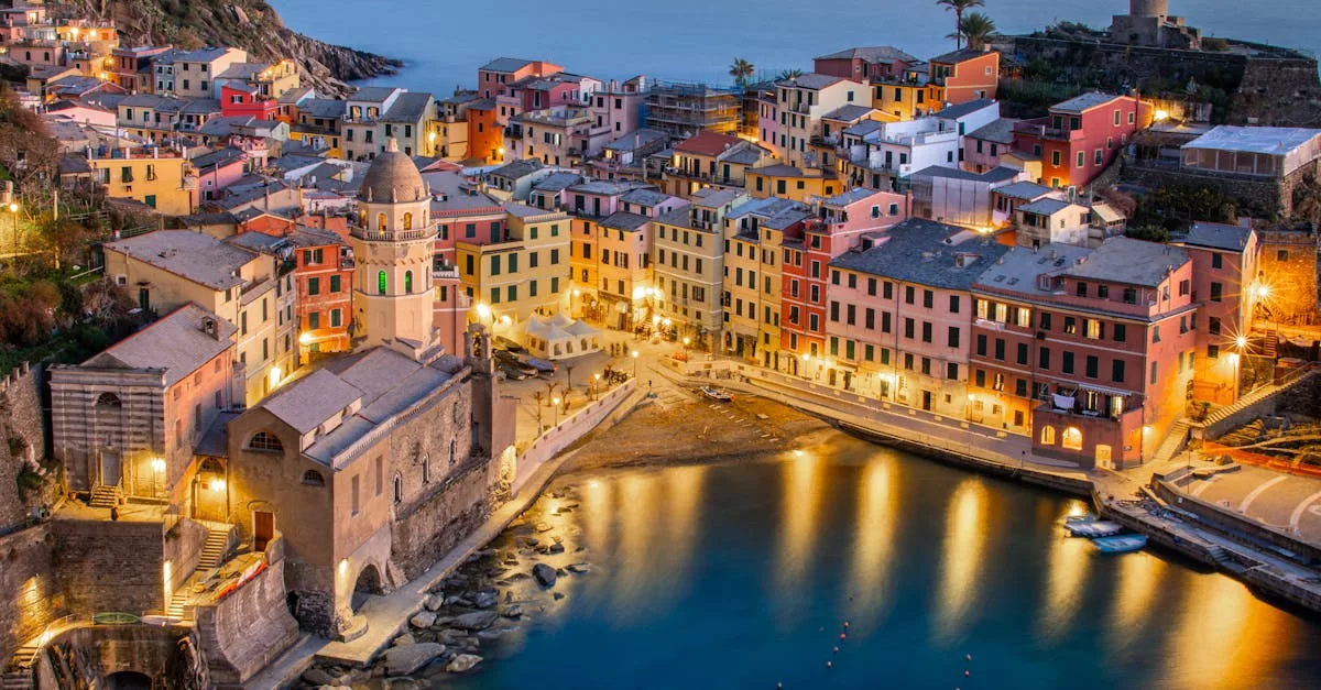 Stunning aerial view of Vernazza's colorful buildings and serene coastline during evening twilight.